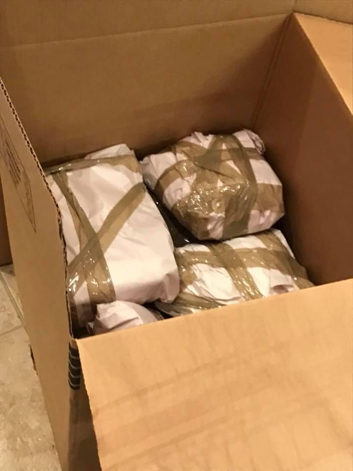 A cardboard box filled with clothes wrapped in tape 28.4845° N, 81.2519° W