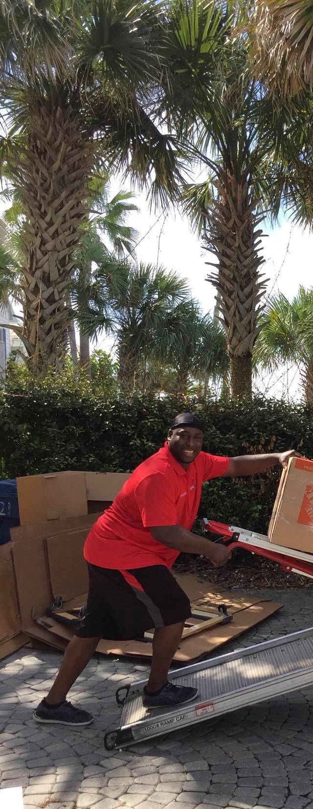 A man in a red shirt is pushing a box on a ramp.