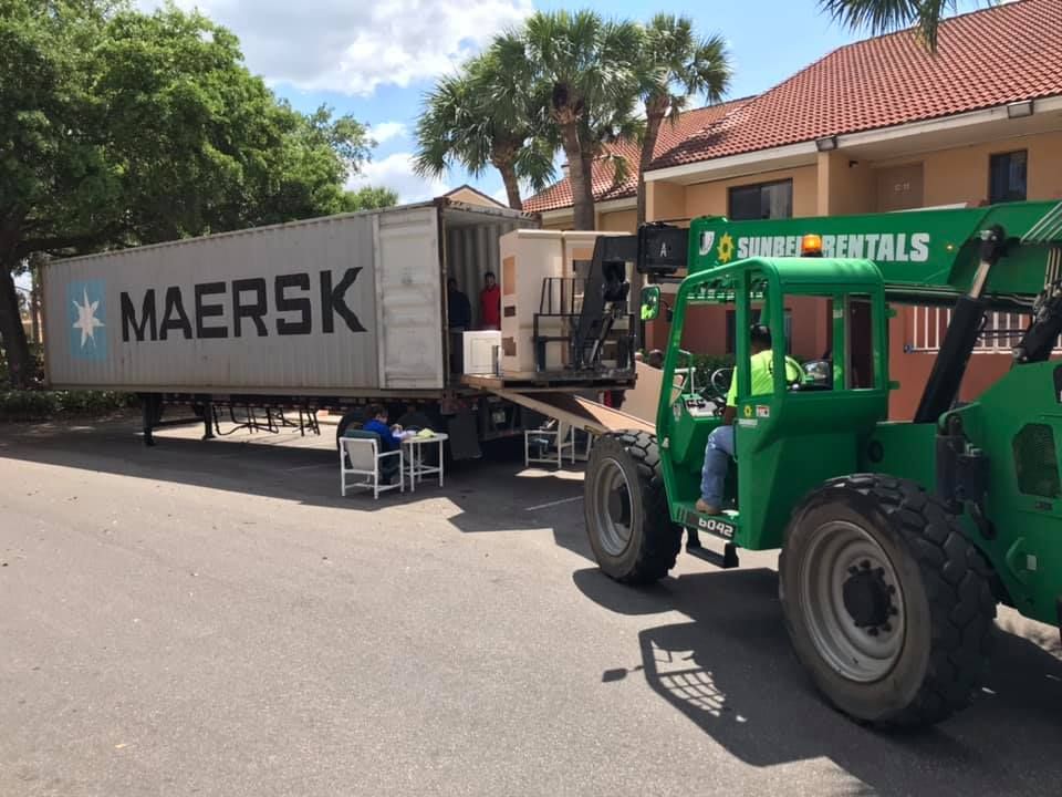 A man is driving a forklift next to a Maersk truck 28.4845° N, 81.2519° W
