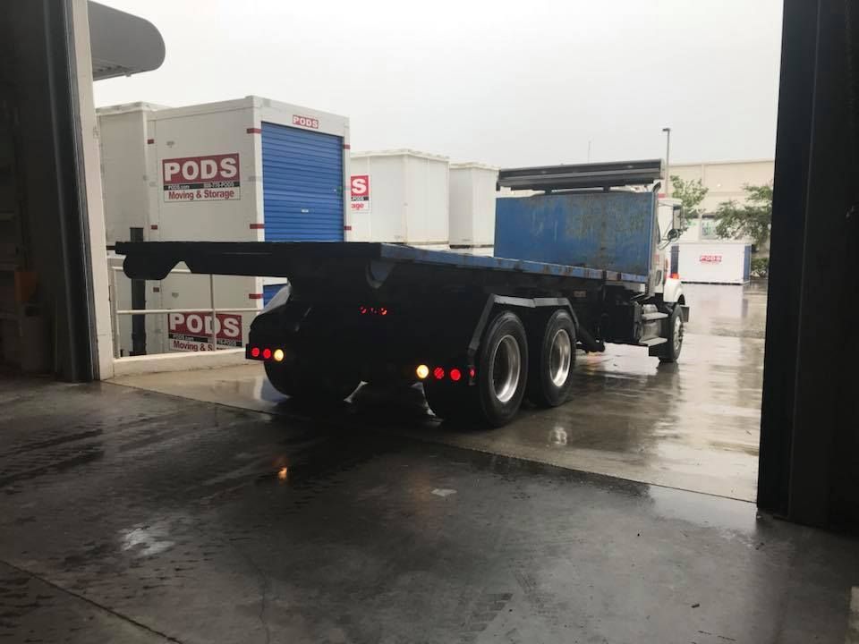 A truck is parked in front of a pods storage facility 28.4845° N, 81.2519° W