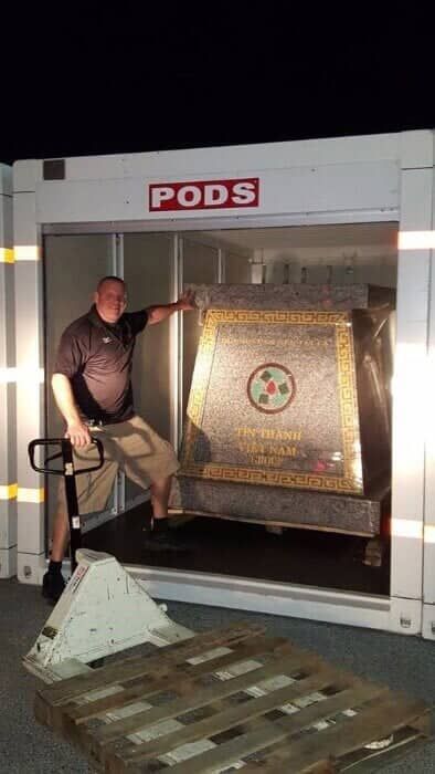 A man is standing in front of a pods container. 28.4845° N, 81.2519° W