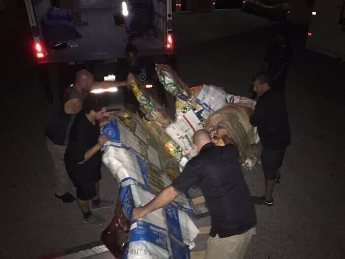A group of men are loading a truck with lots of groceries 28.4845° N, 81.2519° W