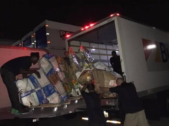 Two men are loading boxes into a truck at night 28.4845° N, 81.2519° W