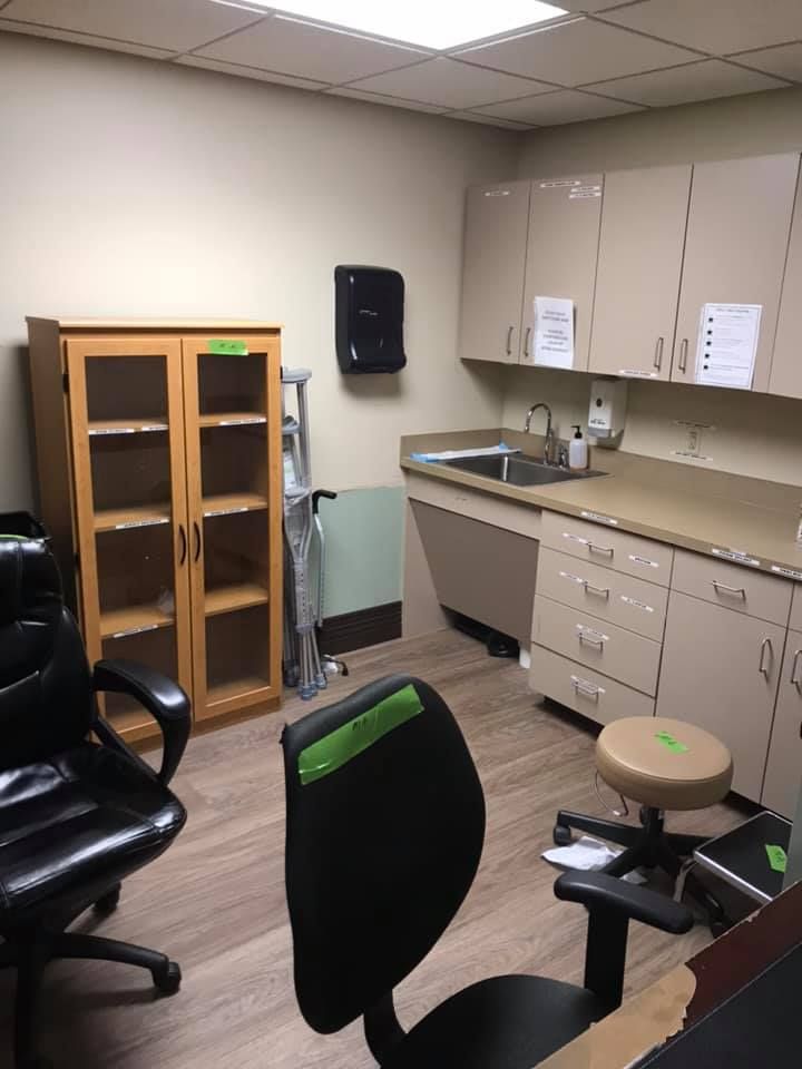 A kitchen with a sink and cabinets and a chair 28.4845° N, 81.2519° W