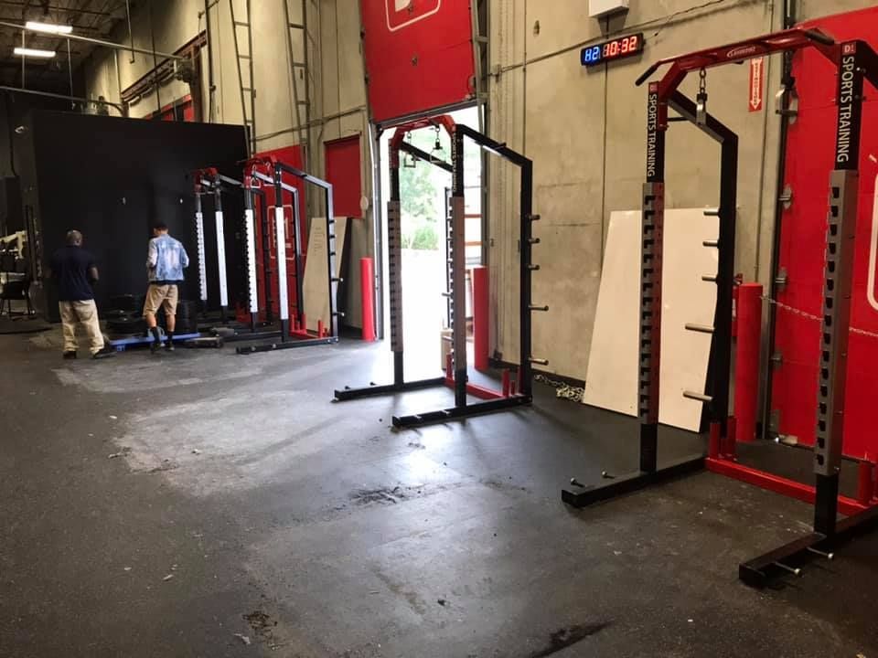 A row of squat racks are lined up in a gym. 28.4845° N, 81.2519° W