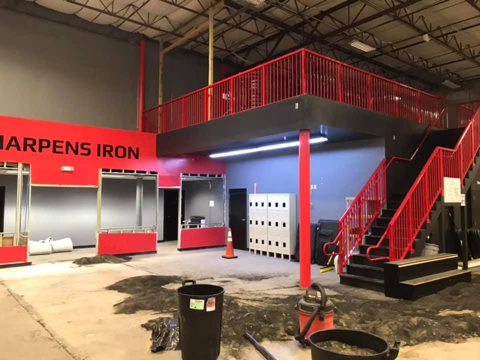 A large room with stairs and a sign that says happens iron 28.4845° N, 81.2519° W