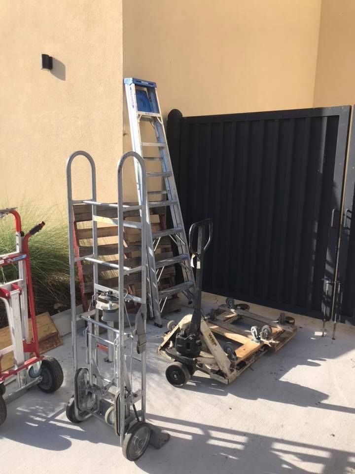 A ladder is sitting on top of a cart in front of a building. 28.4845° N, 81.2519° W