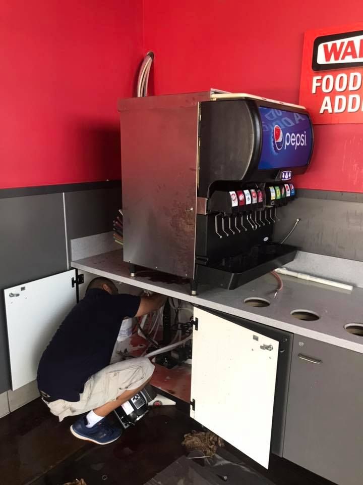 A man is working under a Pepsi machine in a restaurant 28.4845° N, 81.2519° W