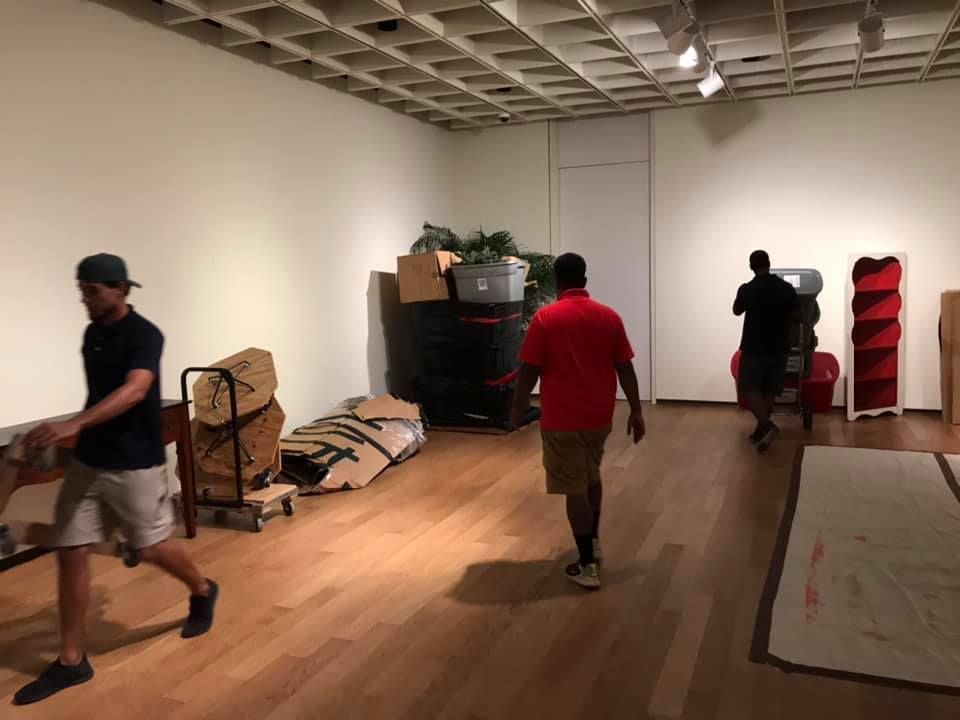 A group of men are moving boxes in a room. 28.4845° N, 81.2519° W