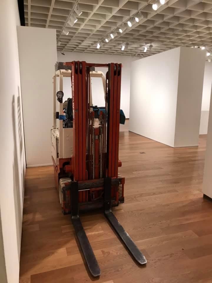 A red forklift is parked in a large empty room. 28.4845° N, 81.2519° W