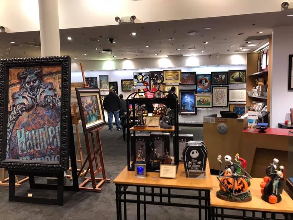 A room with a lot of paintings on display and a table with a pumpkin on it 28.4845° N, 81.2519° W