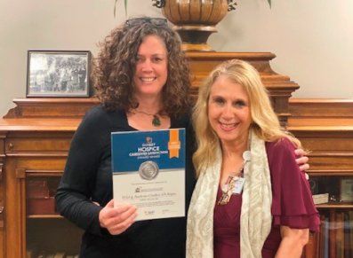 Two women are standing next to each other holding a certificate.
