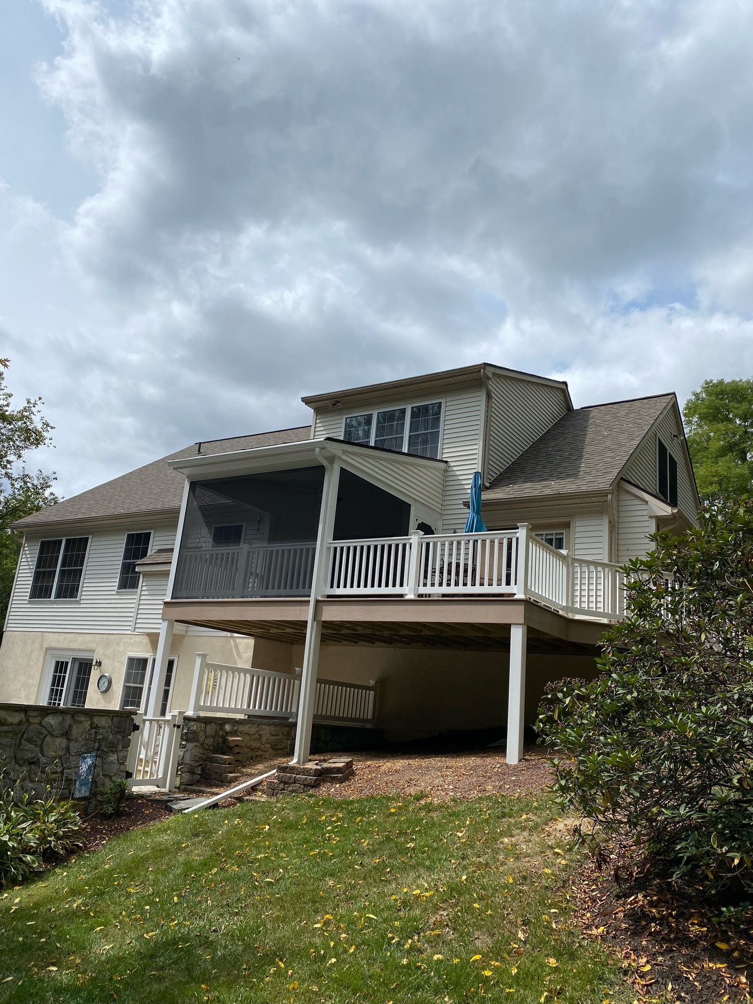 Suburban house with raised porch and stairs on a cloudy day