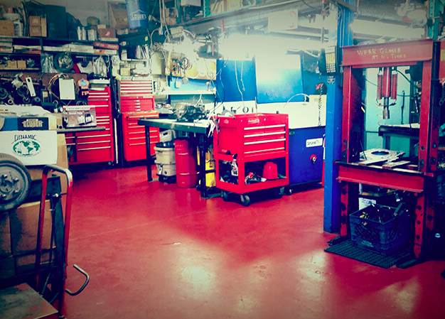 A garage with a lot of tools and a red floor