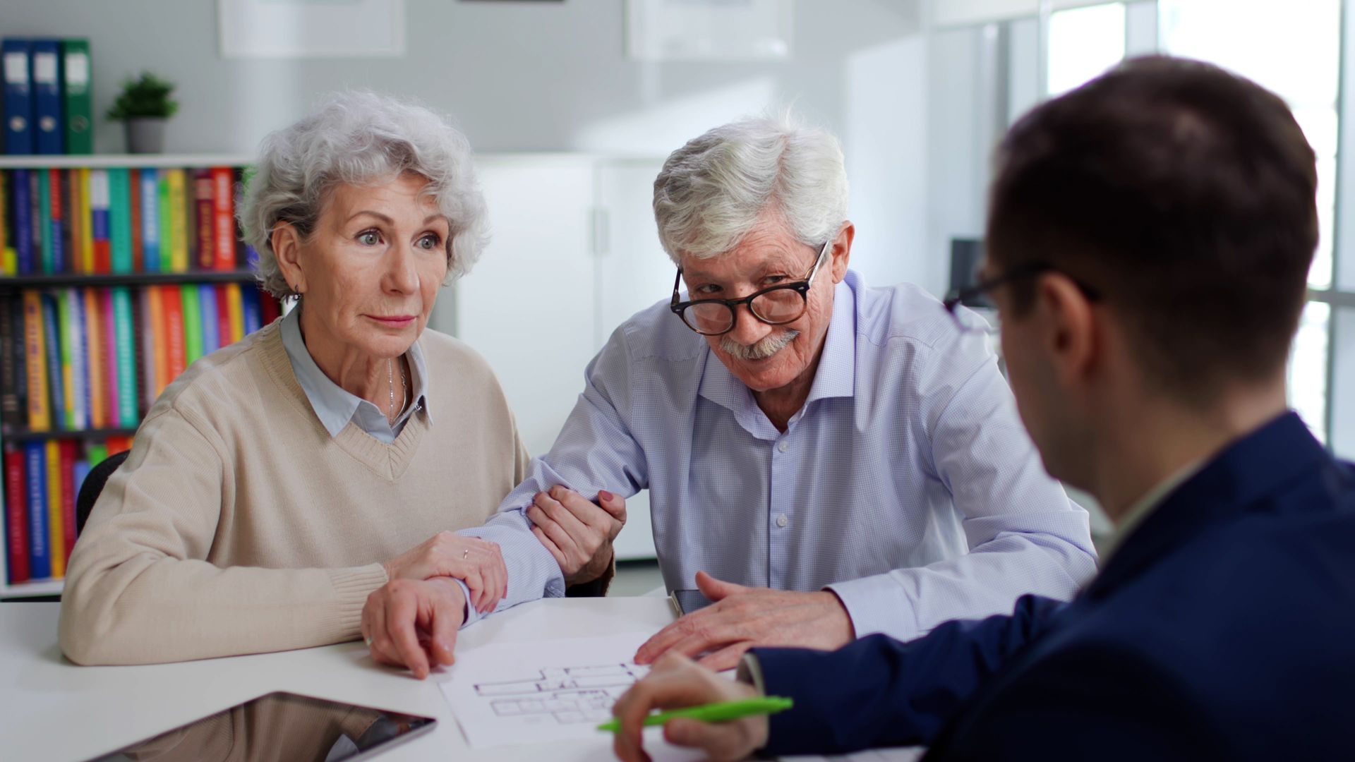 A couple meeting with an attorney to review and sign their will documents.