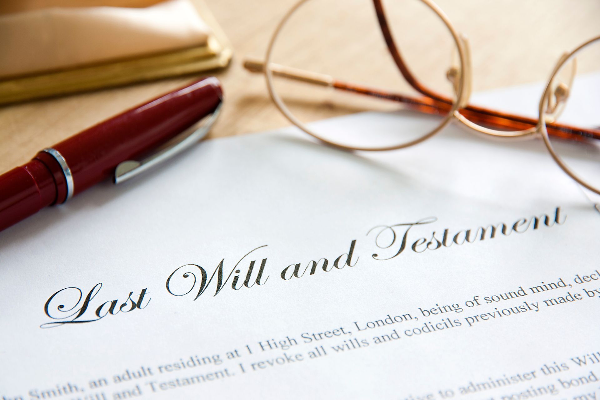 Last will and testament document with pen and glasses.