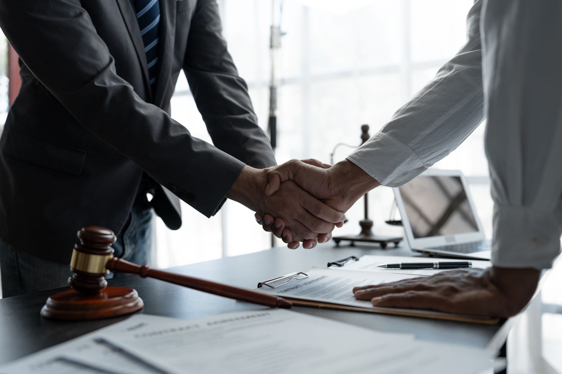 A trust attorney shaking hands with a client in his office. A trust attorney shaking hands with a client in his office.