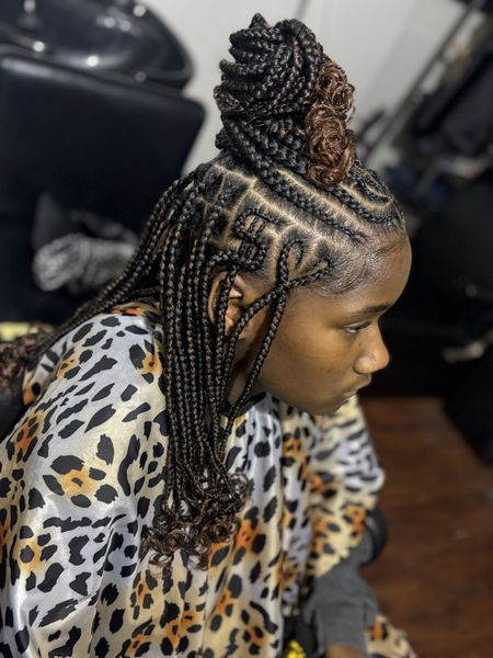 Braided hairstyle with cornrows and a high bun on a person in a leopard-print salon cape
