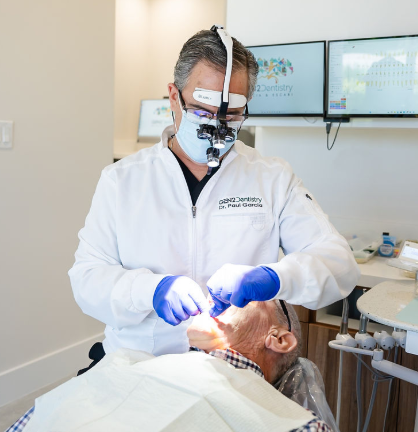 Dr. Paul Garcia with magnifying loupes treating a patient