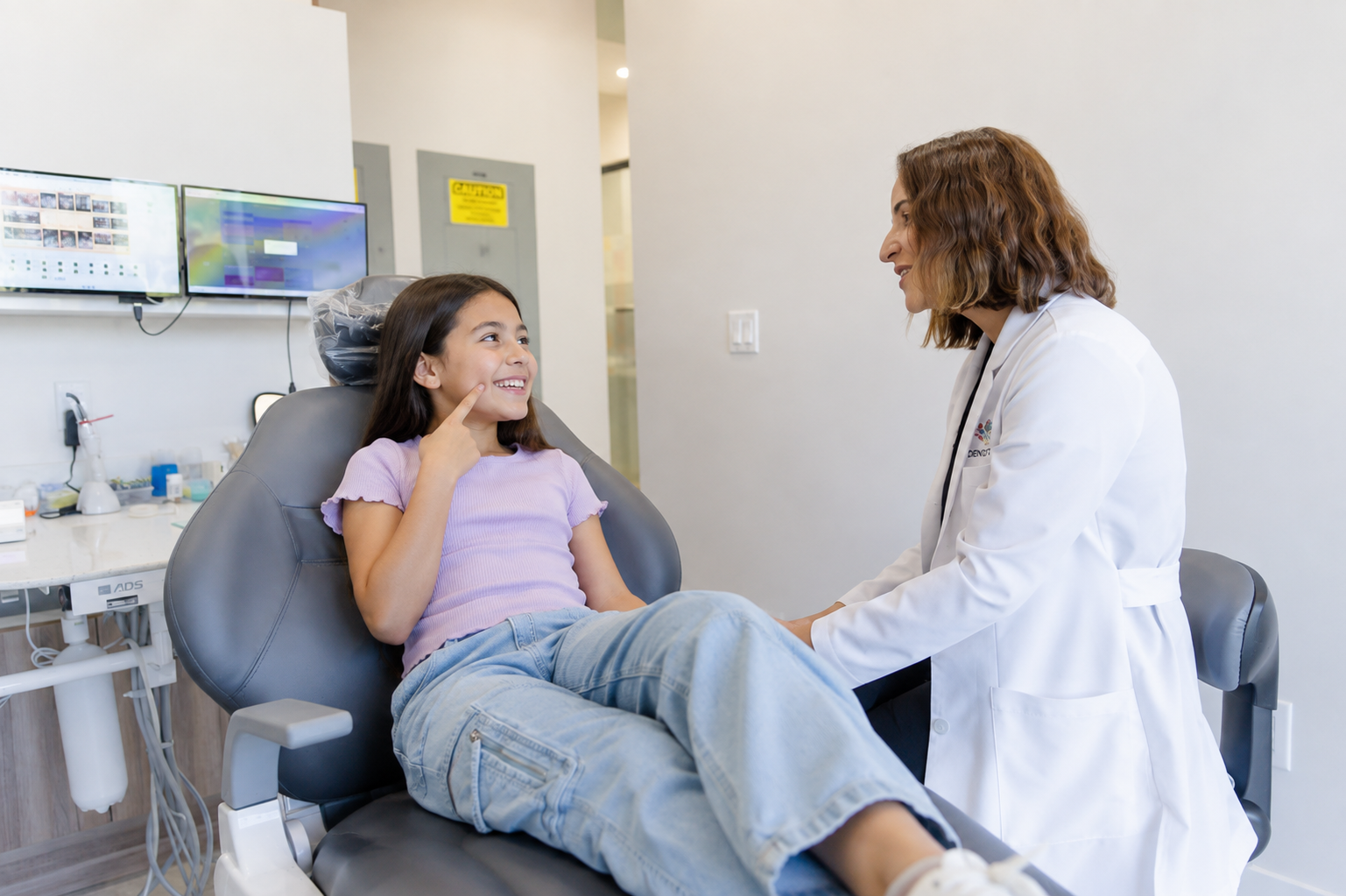 Dr. María Escabí with a smiling young patient at our Davie dental office