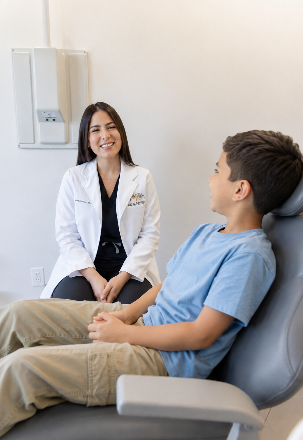 Dr. María Escabí talking with a young patient in the dental chair