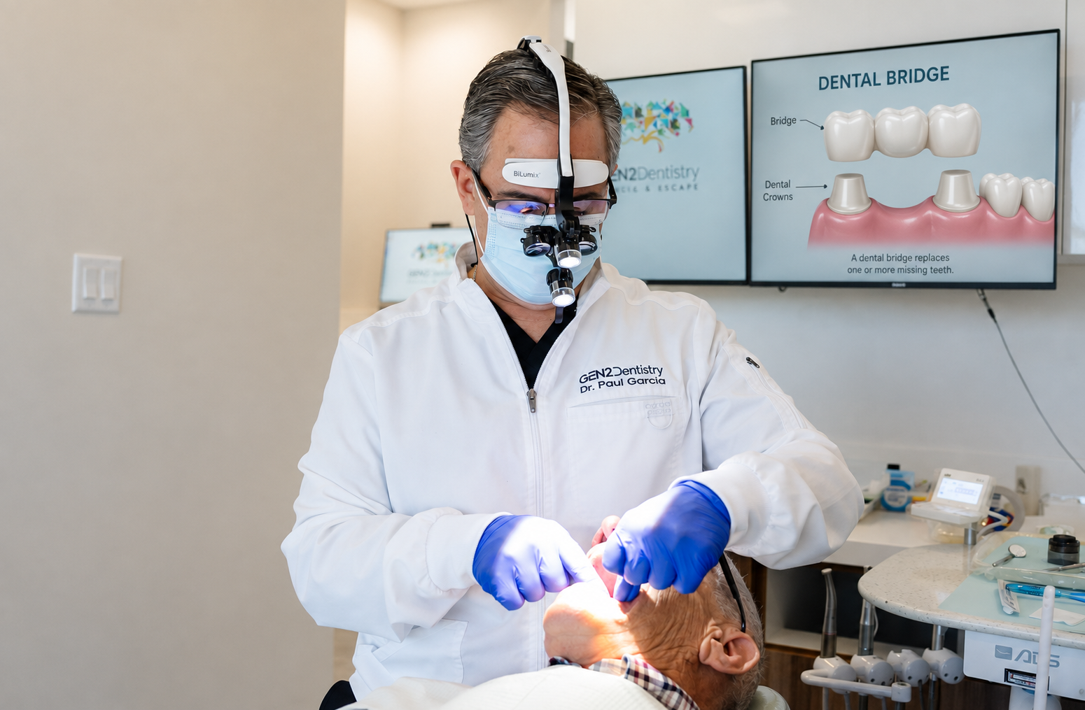 Dr. Paul Garcia treating a patient with a dental bridge diagram behind him