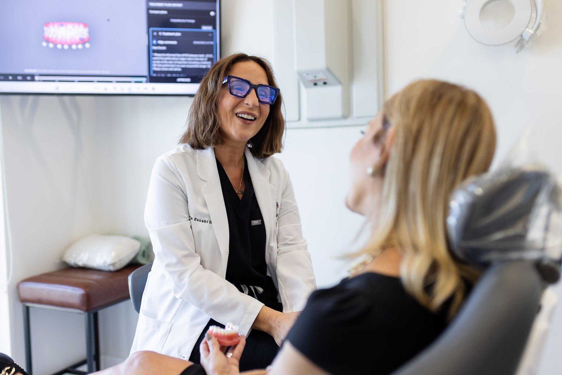 Dr. María Escabí laughing with a patient during a filling consult