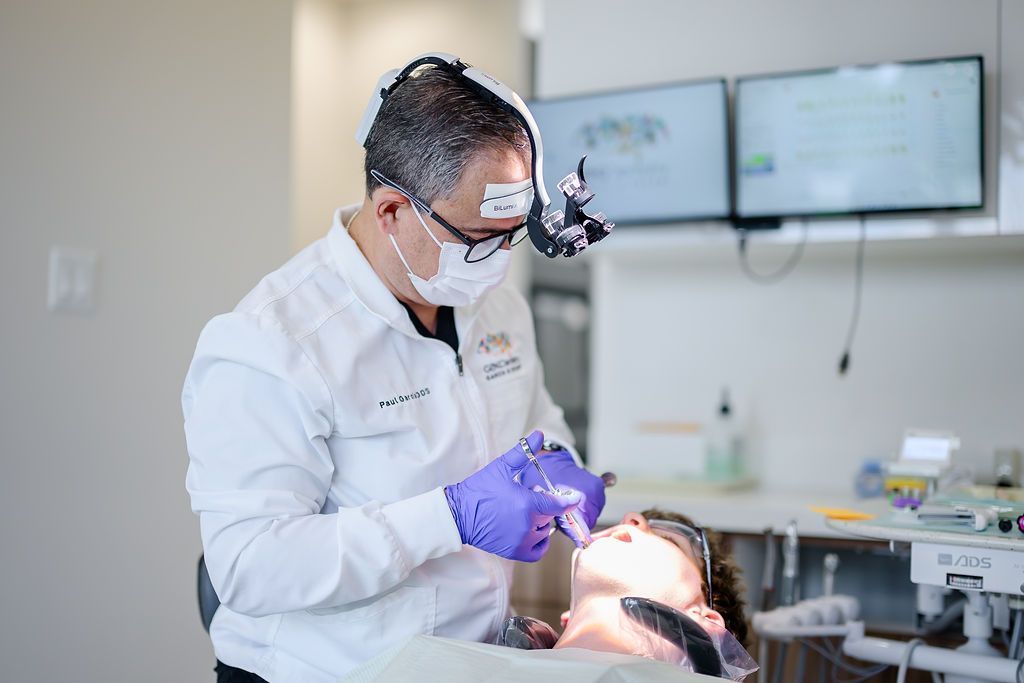 Dentist wearing magnifying loupes treating a patient's tooth