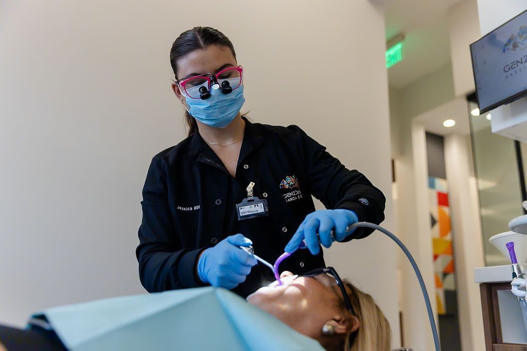 Hygienist wearing loupes caring for a patient at GEN2 Dentistry