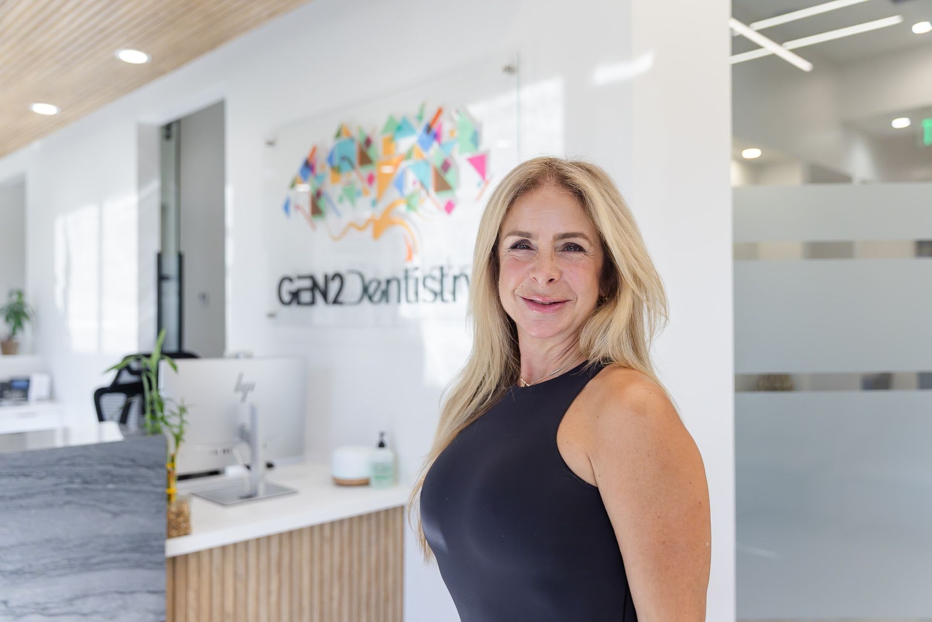 Front desk team member welcoming patients at GEN2 Dentistry