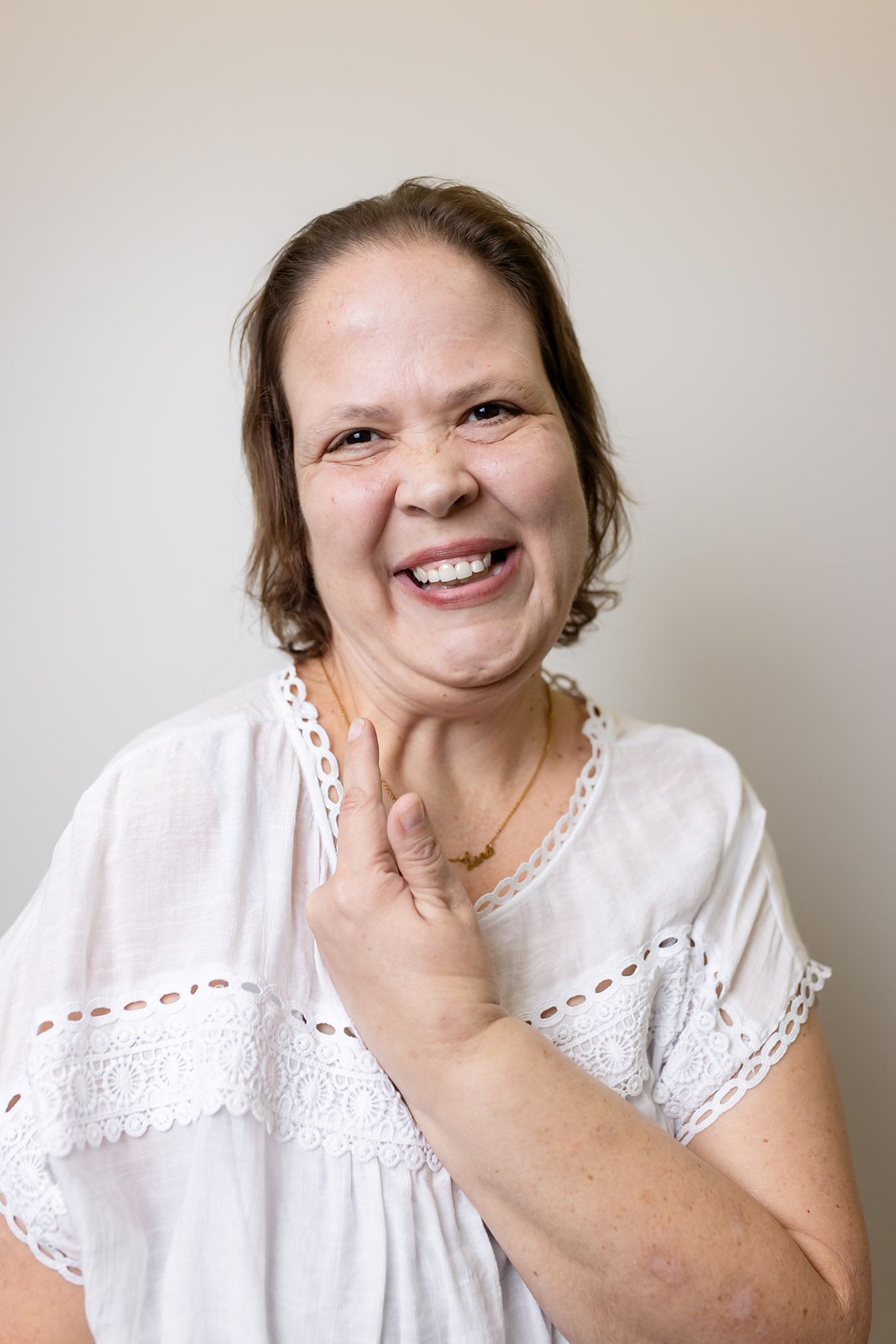 Patient laughing with a hand at her chin at GEN2 Dentistry