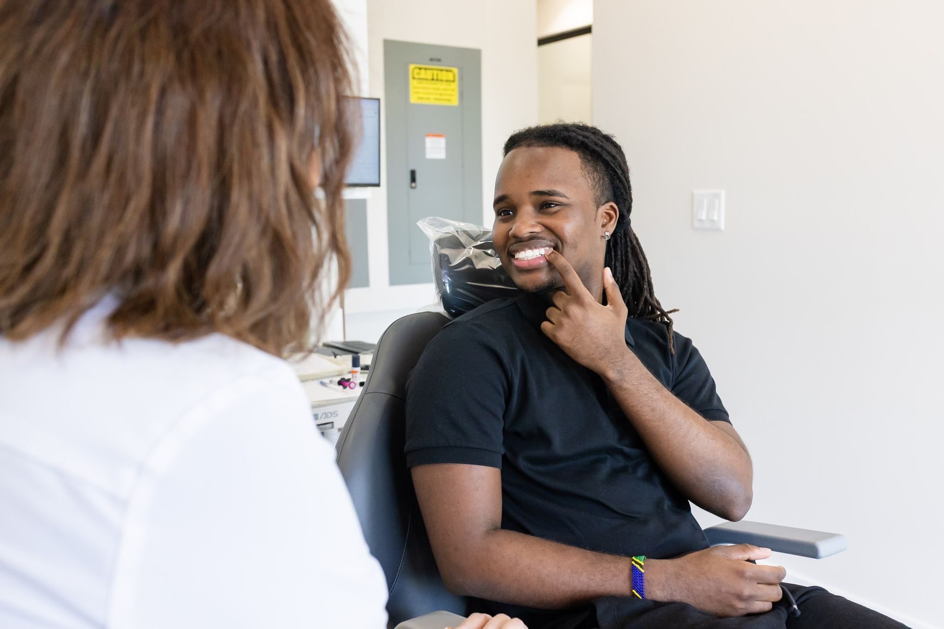 Smiling patient talking with the dentist in the dental chair