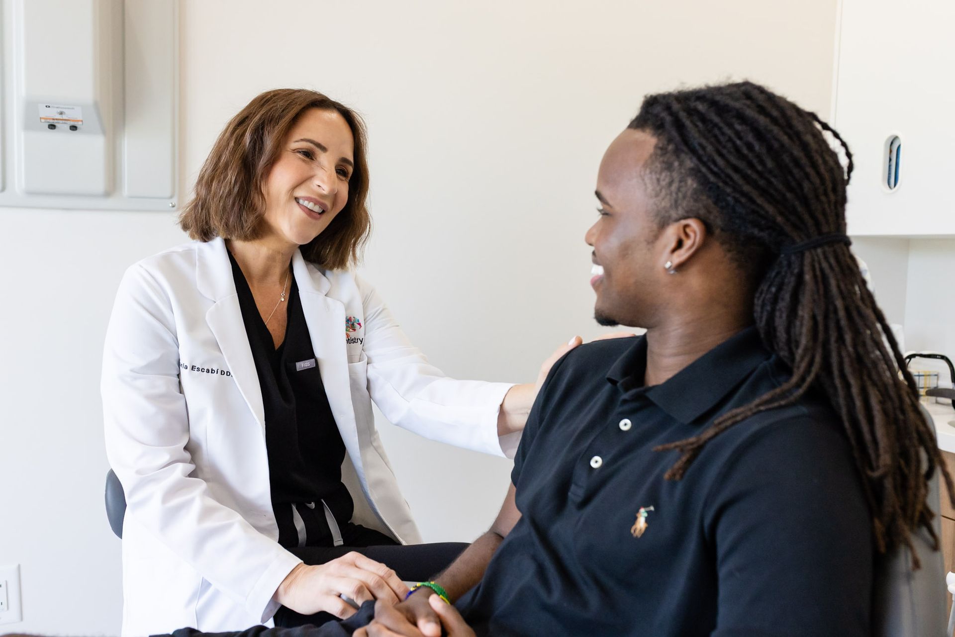 Dr. María Escabí and a smiling patient talking chairside