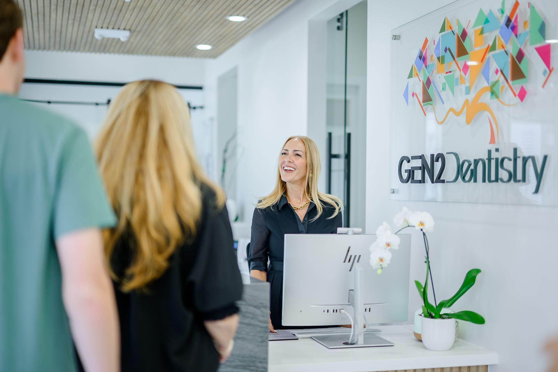 Front desk team member checking in a new patient at GEN2 Dentistry