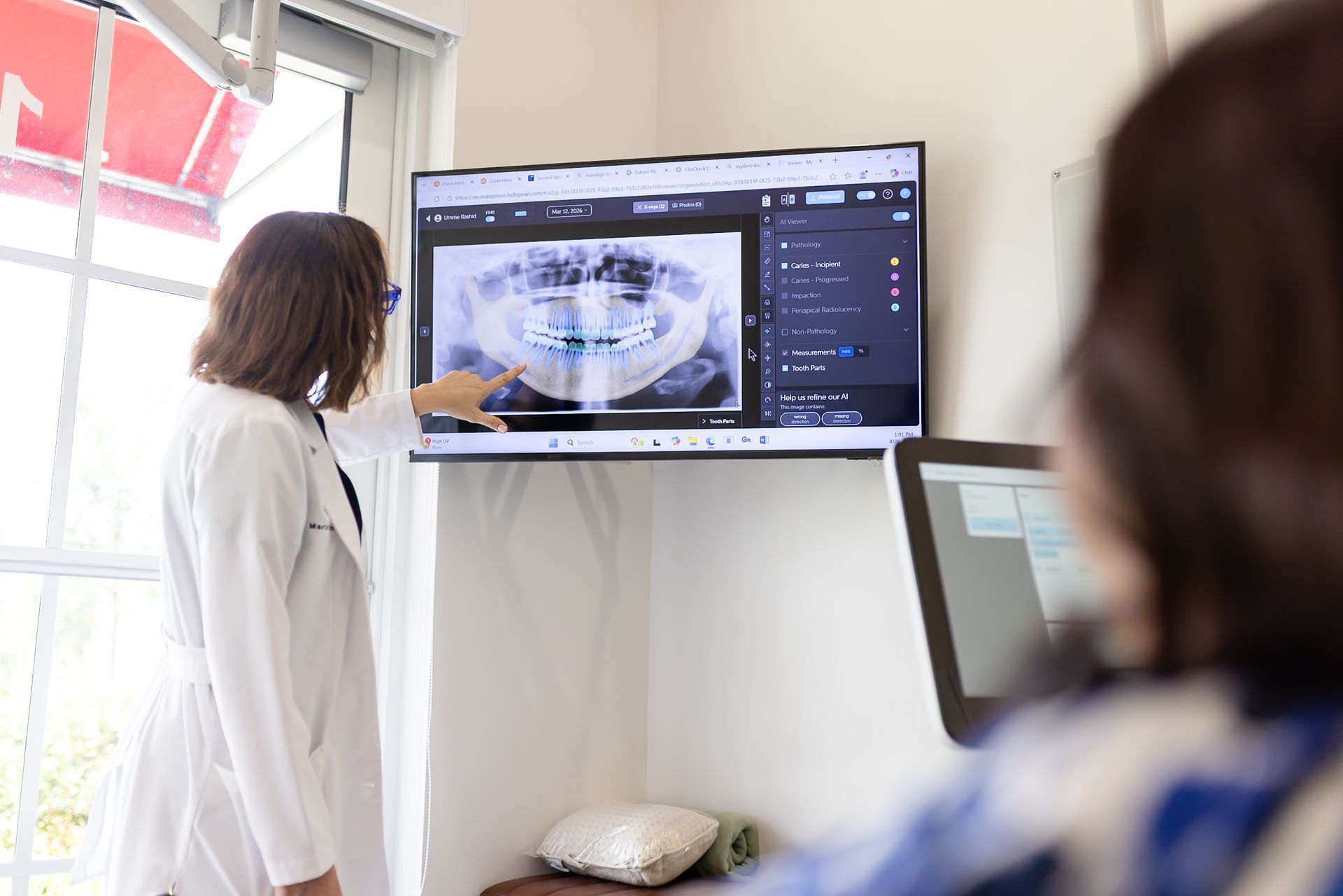 Dr. María Escabí reviewing a panoramic X ray with a patient