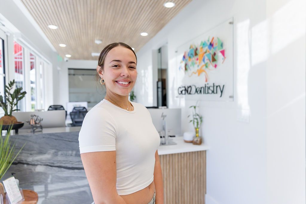 Smiling patient in the GEN2 Dentistry lobby in Davie, FL, after a dental visit