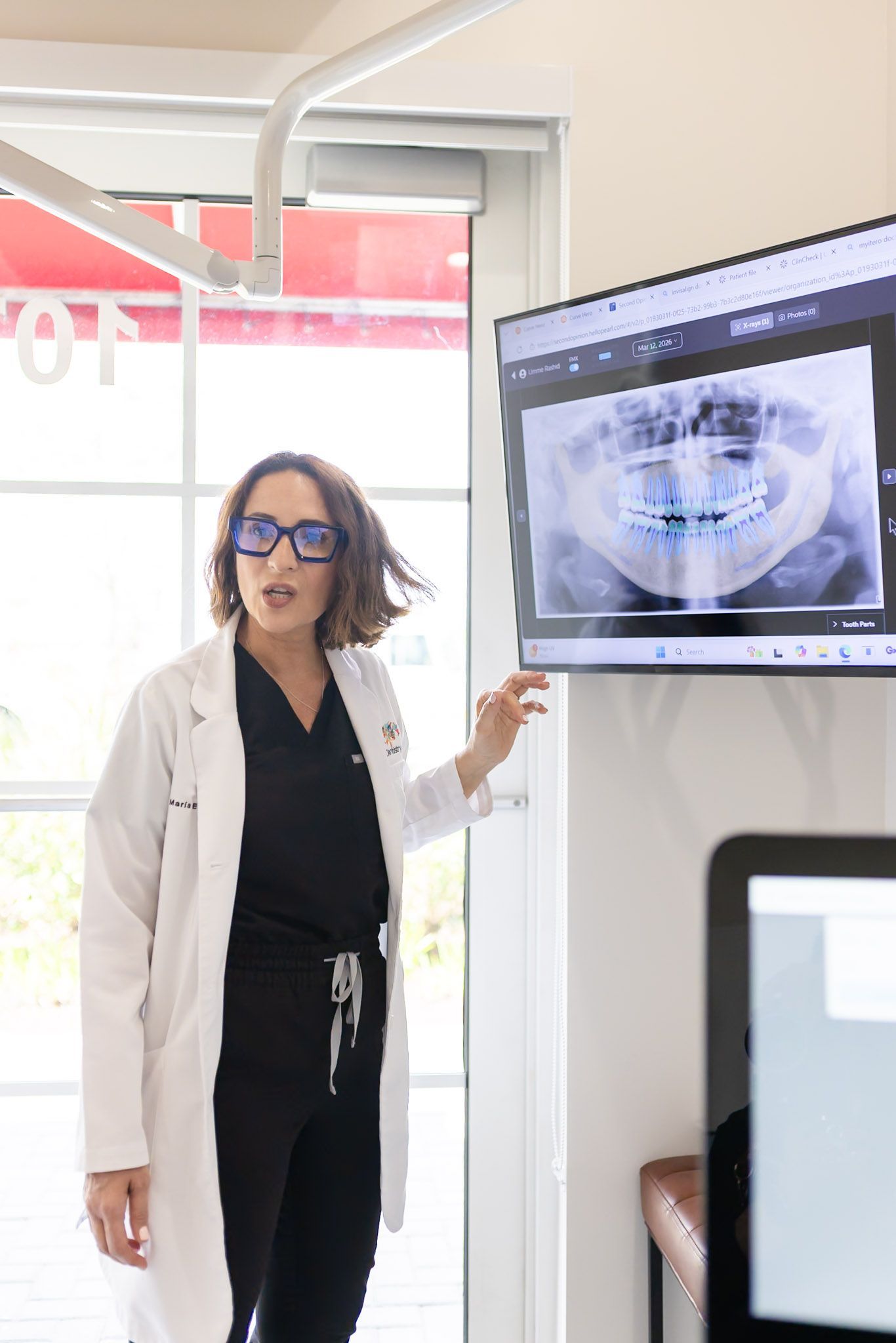 Dr. María Escabí pointing to an X ray while planning an extraction
