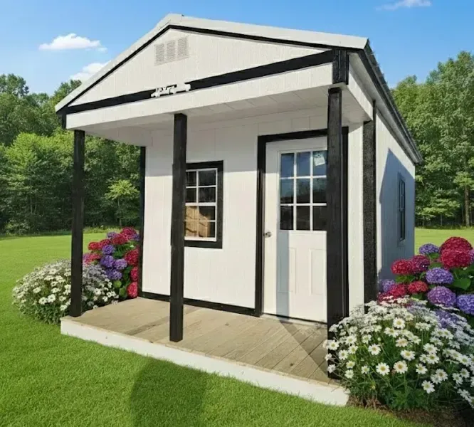Small white cabin with black trim and front porch