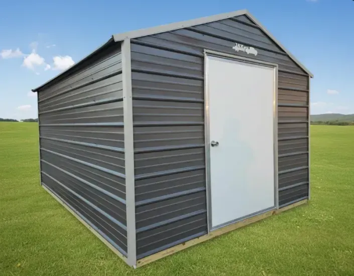 Gray metal storage shed with white door on a grassy field under a blue sky
