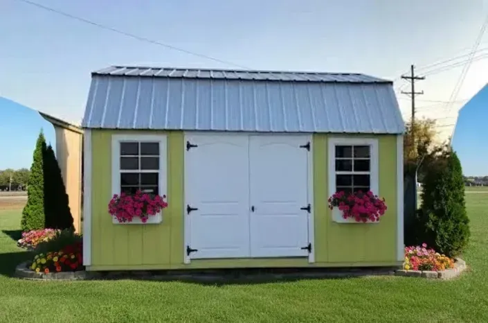 Small yellow garden shed with white double doors, flower boxes, and a metal roof on a grassy lawn
