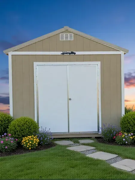 Tan beige garden shed with white double doors, bordered by flowers and a curved stepping-stone path.