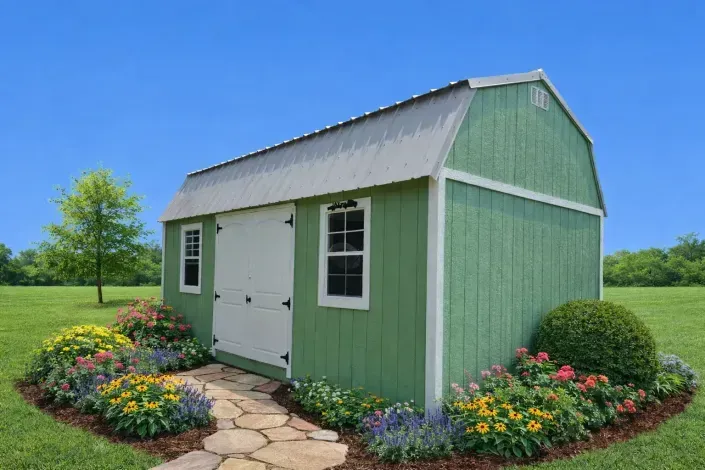 Green garden shed with white doors and flower beds beside a stone path under a blue sky