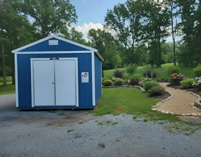 Blue shed with white double doors beside a gravel drive and landscaped path in a park-like setting