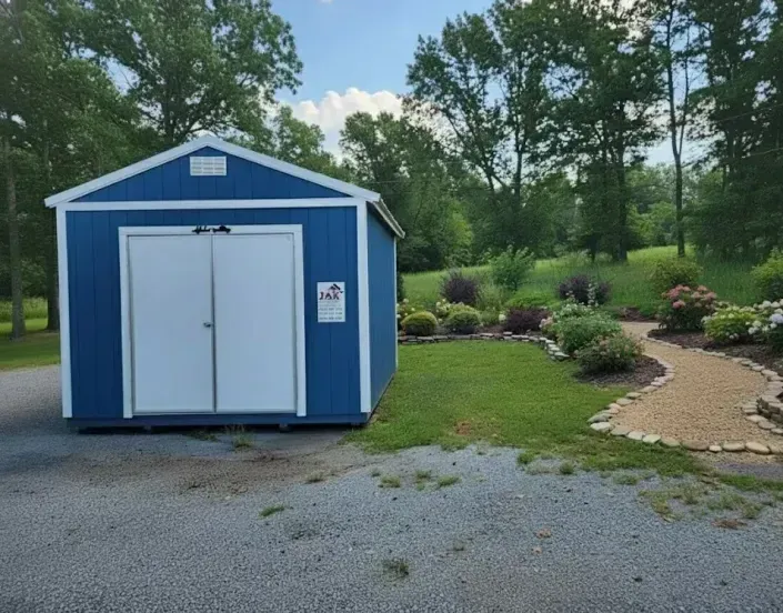 Blue storage shed beside a gravel path in a landscaped park with trees and shrubs.