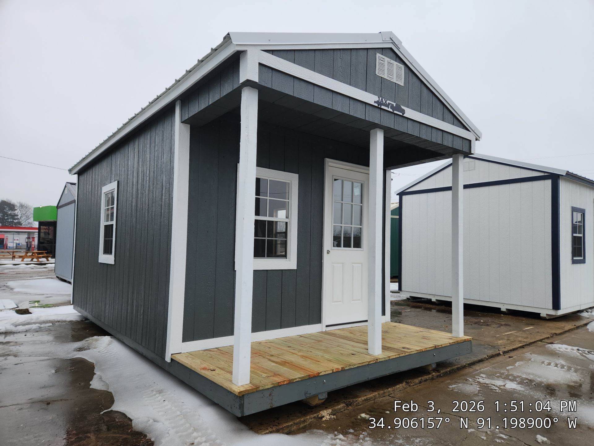 dark gray cabin with front porch and white trim