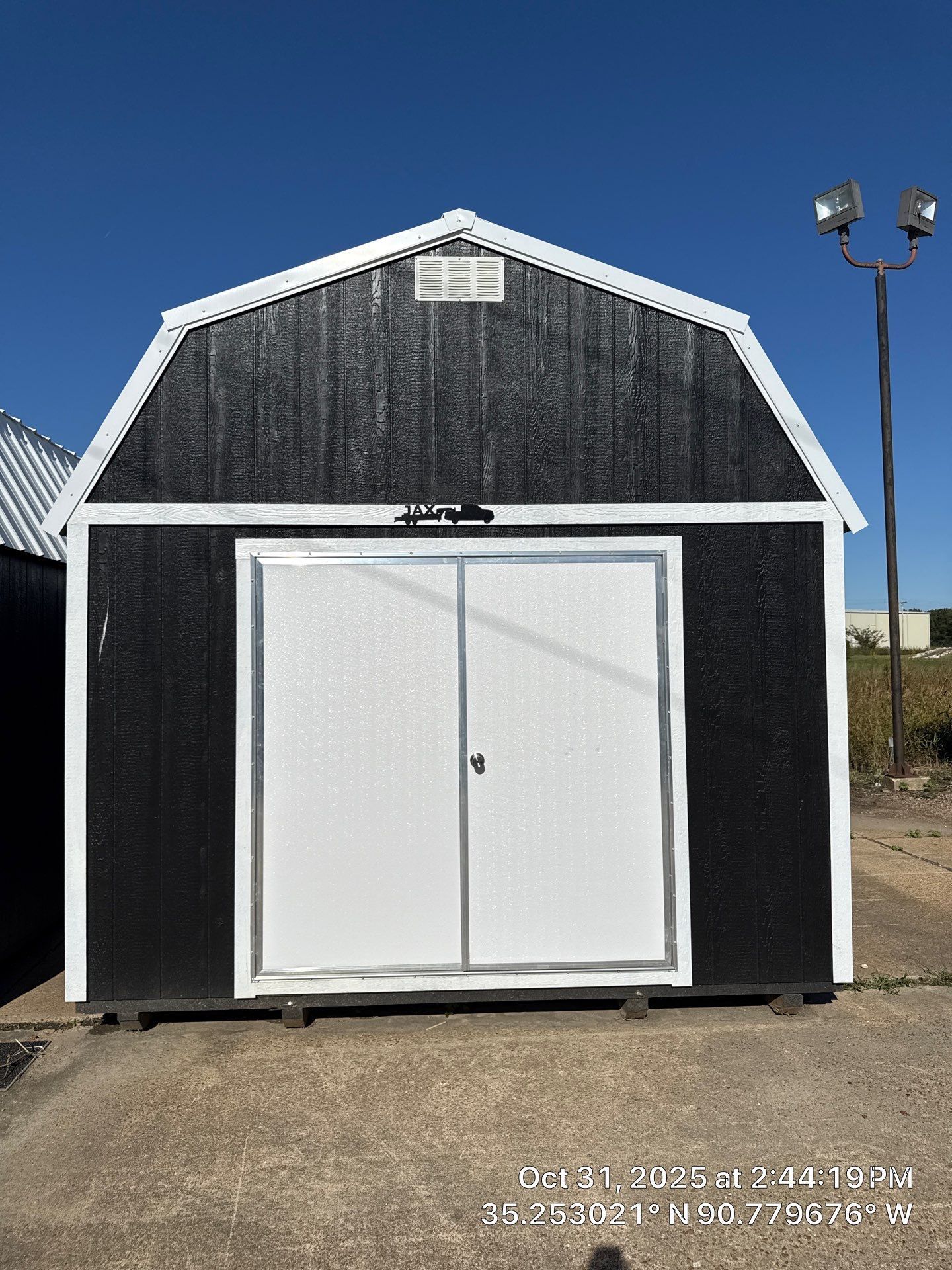 black lofted barn with white trim and double doors