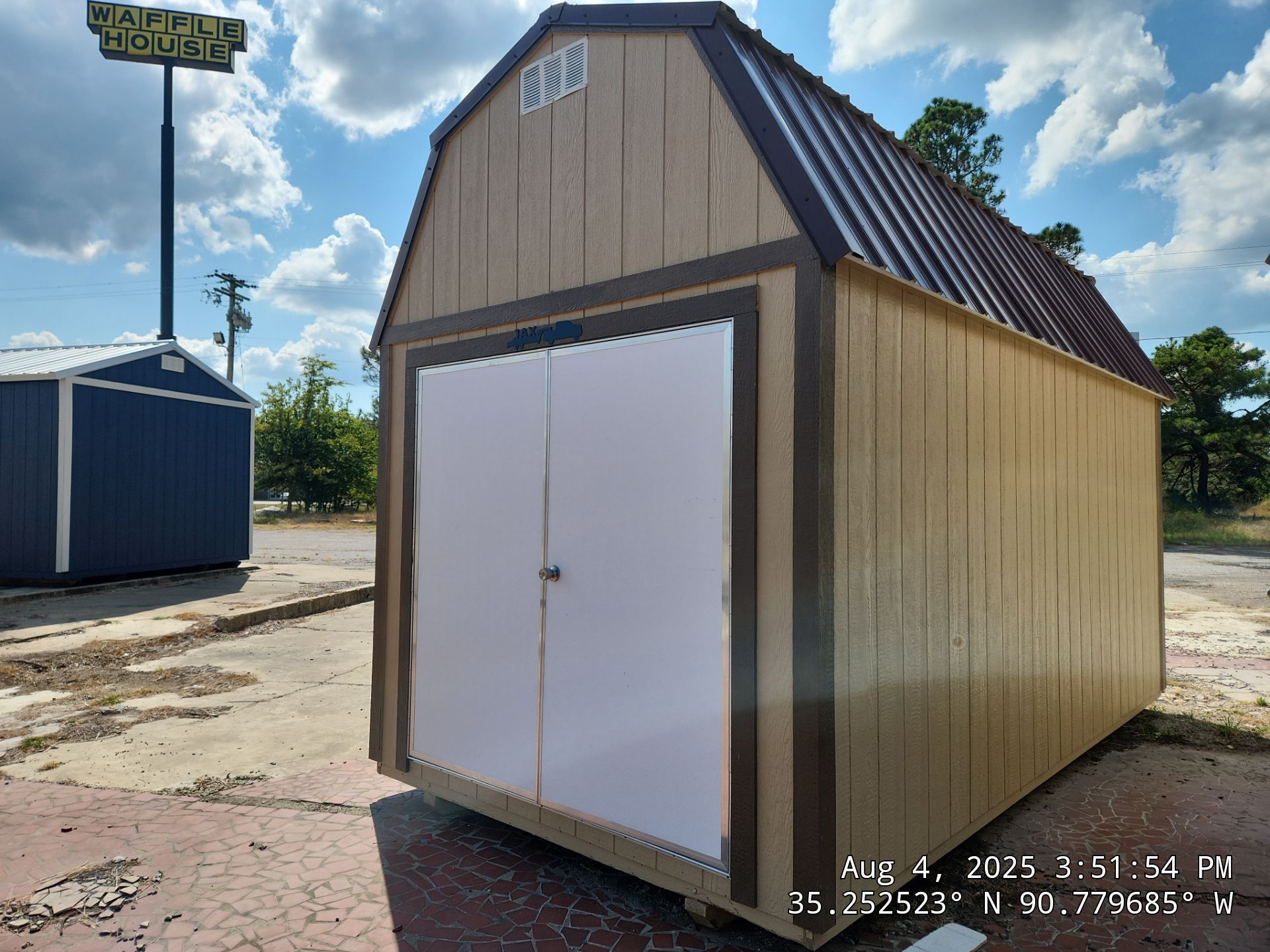 brown lofted barn with double doors and dark brown trim