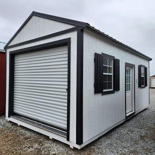 white side garden shed with roll up door and black trim