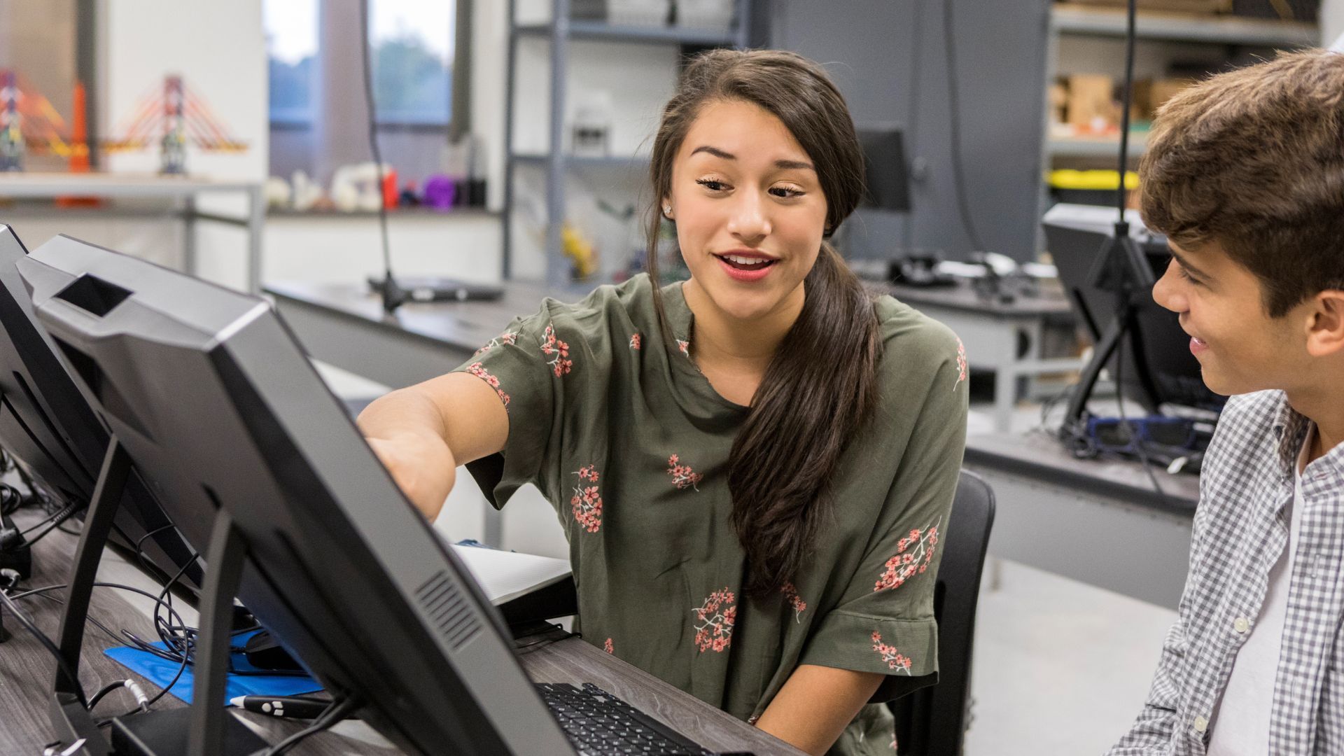 Everything you need to know about entrepreneurship at school. the image shows a teenage girl showing something to her colleague on the computer screen