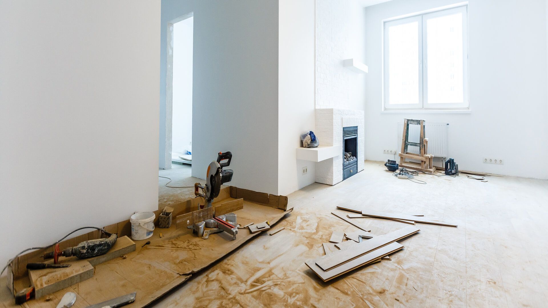 A room under construction with a lot of tools on the floor.